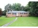 Charming brick home featuring a well-manicured lawn and inviting walkway at 1227 Flowe Dr, Matthews, NC 28104
