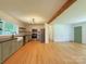 Open kitchen with stainless steel appliances, floating shelves, farmhouse sink, and natural light hardwood flooring at 1227 Flowe Dr, Matthews, NC 28104