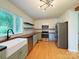 Modern kitchen featuring stainless steel appliances, wood countertops, and a farmhouse sink at 1227 Flowe Dr, Matthews, NC 28104