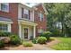 Charming townhome entrance with brick facade, decorative door, and manicured landscaping at 12342 Swan Wings Pl, Huntersville, NC 28078