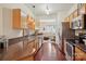 Functional kitchen with wood cabinets, stainless steel appliances, and adjacent living area at 12342 Swan Wings Pl, Huntersville, NC 28078