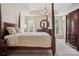 Elegant primary bedroom with a four-poster bed, tray ceiling, and ample natural light at 12342 Swan Wings Pl, Huntersville, NC 28078