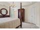 Spacious primary bedroom featuring a four-poster bed, carpeting, and a large wardrobe at 12342 Swan Wings Pl, Huntersville, NC 28078