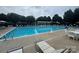 Community pool with clear blue water, lounge chairs, and shaded pergola area for relaxing at 12342 Swan Wings Pl, Huntersville, NC 28078