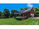 Backyard brick home with deck and stairs leading to large manicured lawn at 1240 Fawn Ridge Nw Rd, Concord, NC 28027