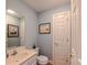 Powder room with a single sink vanity, toilet, and framed artwork on the light blue walls at 1240 Fawn Ridge Nw Rd, Concord, NC 28027