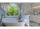 Elegant soaking tub with a view of lush greenery, modern fixtures, and ample natural light in the bathroom at 1240 Fawn Ridge Nw Rd, Concord, NC 28027