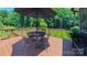 Inviting deck with an umbrella-covered table and chairs overlooks a lush, green lawn, perfect for outdoor entertaining at 1240 Fawn Ridge Nw Rd, Concord, NC 28027
