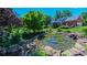 Scenic view of the backyard pond and waterfalls next to the brick home and deck at 1240 Fawn Ridge Nw Rd, Concord, NC 28027