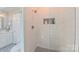 Modern walk-in shower featuring white subway tile, a mosaic tile floor, and a convenient niche for toiletries at 1240 Fawn Ridge Nw Rd, Concord, NC 28027