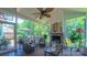 Bright sunroom with a stone fireplace, stylish furnishings, and large windows offering serene outdoor vistas at 1240 Fawn Ridge Nw Rd, Concord, NC 28027