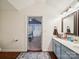 Bright bathroom featuring a blue vanity, wooden floor and an open doorway to the bedroom at 1252 Winding Path Rd, Lake Wylie, SC 29710
