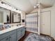 Bathroom features a blue vanity, tiled floors, shower curtain and modern lighting at 1252 Winding Path Rd, Lake Wylie, SC 29710