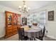 Cozy dining area with modern chandelier, wooden hutch, and large windows with sheer curtains at 1252 Winding Path Rd, Lake Wylie, SC 29710