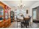 Cozy dining area with modern chandelier, wooden hutch, and large windows with sheer curtains at 1252 Winding Path Rd, Lake Wylie, SC 29710