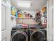 Well-lit laundry room featuring side-by-side washer and dryer and organized shelving for storage at 1252 Winding Path Rd, Lake Wylie, SC 29710