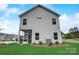 Rear exterior view features white siding, green lawn, small patio, and manicured landscaping at 1254 Langston Ln, Salisbury, NC 28144