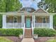 Charming home featuring a welcoming front porch with swing and vibrant blue door at 1325 Kennon St, Charlotte, NC 28205