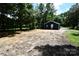 A large cleared lot shows a view of the home's rear, surrounded by mature trees at 1406 Caldwell St, Gastonia, NC 28052