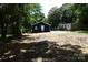 View of a cleared lot, showing the rear of the home and some surrounding greenery at 1406 Caldwell St, Gastonia, NC 28052