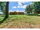Backyard of a brick home with a metal roof, carport, and grassy lawn under a bright sky at 142 Single Oak Dr, Troutman, NC 28166