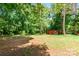 Expansive backyard featuring lush trees and a small red outbuilding in a serene, wooded setting at 142 Single Oak Dr, Troutman, NC 28166
