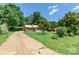 Quaint brick home with a metal roof, carport, and a spacious front yard at 142 Single Oak Dr, Troutman, NC 28166