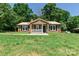 Charming brick home with a covered porch and front yard, surrounded by trees at 142 Single Oak Dr, Troutman, NC 28166
