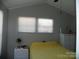 Cozy bedroom featuring a sloped ceiling, white furniture, and plenty of natural light from two windows at 166 Eagle Dr, New London, NC 28127