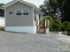 Charming home featuring gray siding, a white base, and a small porch with wooden stairs at 166 Eagle Dr, New London, NC 28127