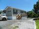 Charming single-story home featuring a wooden deck, gray siding, and a gravel driveway for easy parking at 166 Eagle Dr, New London, NC 28127