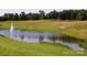Picturesque pond featuring a fountain, surrounded by lush green grass and scattered trees, perfect for outdoor serenity at 166 Eagle Dr, New London, NC 28127
