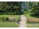 Expansive backyard with lush greenery, a stone pathway, and mature trees creating a serene setting at 1928 Providence Rd, Charlotte, NC 28211