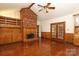 This living room features hardwood floors, a ceiling fan, and a brick fireplace at 1928 Providence Rd, Charlotte, NC 28211