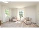 Bright sitting area with two armchairs, a glass-topped coffee table, and large windows lets in abundant natural light at 1928 Providence Rd, Charlotte, NC 28211