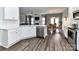 Open kitchen flowing into a dining area, featuring white cabinets, stainless steel appliances, and hardwood floors at 2003 Trigger Dr, Indian Trail, NC 28079