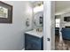 Stylish powder room with a blue vanity, marble countertop, and gold fixtures at 2003 Trigger Dr, Indian Trail, NC 28079