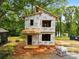 New home under construction featuring the exterior framing and sheathing against a backdrop of mature trees at 207 Knot St, Shelby, NC 28150