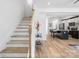 Elegant staircase leading to the upper level, with a view of the modern kitchen and open living space at 213 Knot St, Shelby, NC 28150