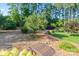 Picturesque backyard featuring a wooden bridge, mature trees, and manicured landscaping at 230 Washam Rd, Mooresville, NC 28117