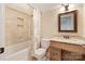 Well-lit bathroom featuring a bathtub with shower, toilet, and vanity with framed mirror at 230 Washam Rd, Mooresville, NC 28117