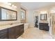Luxurious bathroom with dual vanities, freestanding tub, stone accent wall, and access to a walk-in closet at 230 Washam Rd, Mooresville, NC 28117