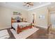 Comfortable bedroom featuring tray ceilings, modern fan, beautiful hardwood floors, and ample natural light at 230 Washam Rd, Mooresville, NC 28117