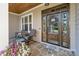 Inviting front porch with wood plank ceiling, rocking chairs, and a charming wreath on a beautiful wood front door at 230 Washam Rd, Mooresville, NC 28117