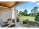 Cozy front porch featuring wicker chairs, potted plants, stone flooring, and a serene view of the landscaped front yard at 230 Washam Rd, Mooresville, NC 28117