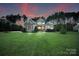 Charming two-story home featuring a lush green lawn, stone accents, and inviting curb appeal with mature trees at 230 Washam Rd, Mooresville, NC 28117