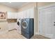 Bright laundry room with custom white cabinetry, granite countertops, and modern washer and dryer at 230 Washam Rd, Mooresville, NC 28117