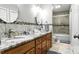 Bathroom with double sinks, granite counters, and decorative tile backsplash at 2367 24Th Street Ne Ln, Hickory, NC 28601