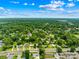 Expansive aerial view of the residential neighborhood, lush green trees, and beautiful blue sky with fluffy clouds at 2919 Dunaire Dr, Charlotte, NC 28205