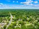 Panoramic aerial view of a neighborhood nestled among mature trees under a blue sky with scattered clouds at 2919 Dunaire Dr, Charlotte, NC 28205